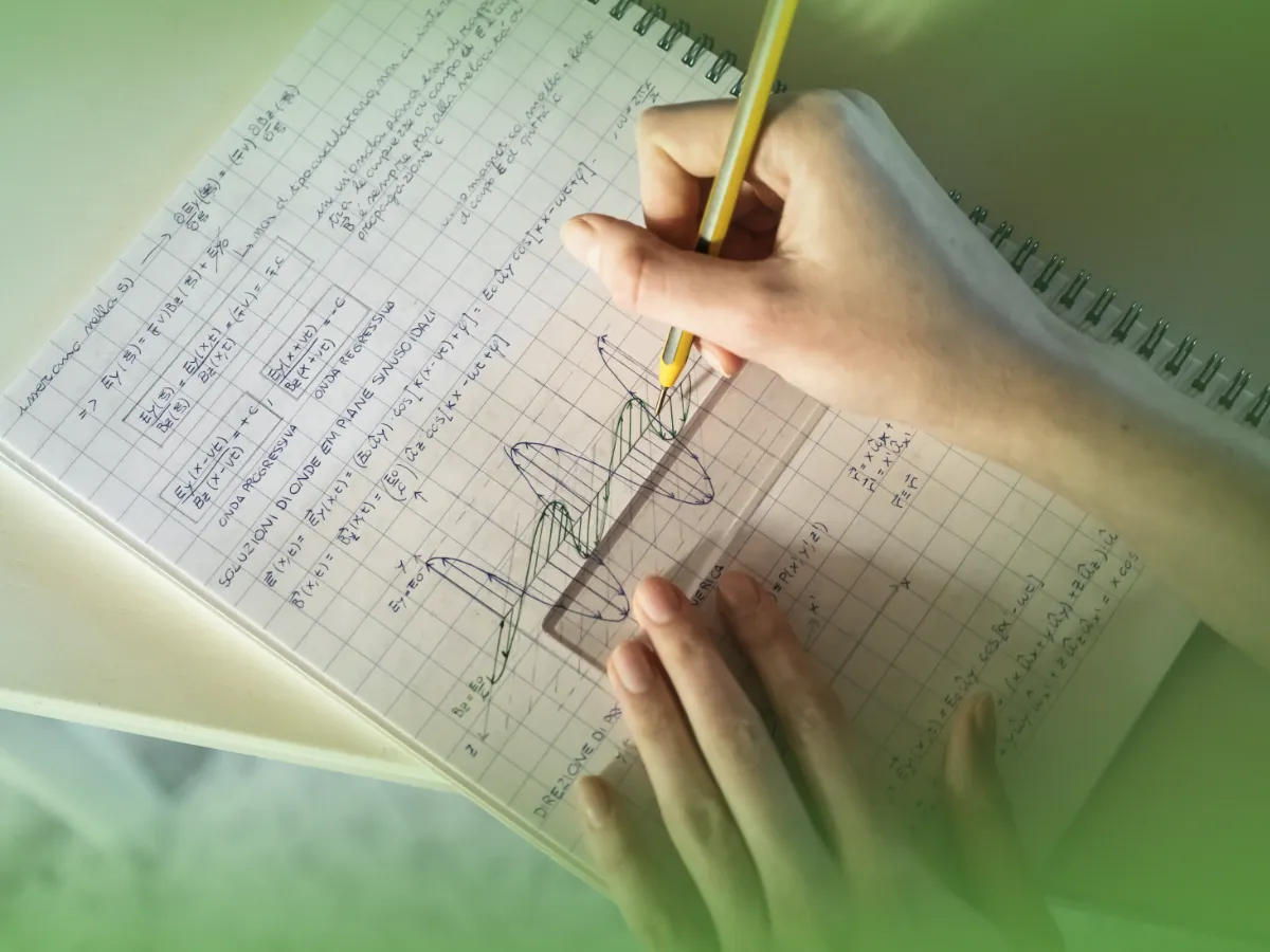 As mãos de uma pessoa escrevendo equações matemáticas e gráficos em um caderno com um lápis.
Explicações de Matemática Aplicada 11.º Ano . Mensalidades