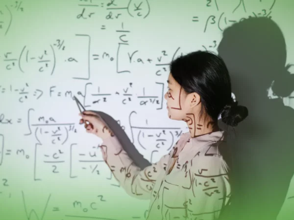 Mulher ensinando, apontando para fórmulas matemáticas complexas projetadas em um quadro.
Nome do Produto: Explicações de Matemática Aplicada 12.º Ano . Mensalidades