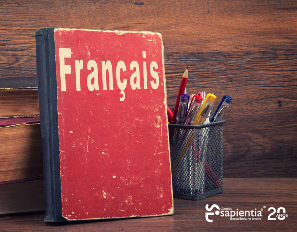 Um livro com a palavra francais está sobre uma mesa de madeira.