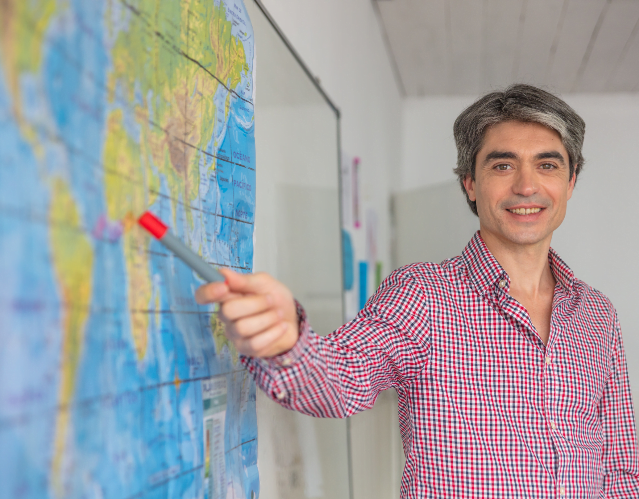 Um homem apontando para um mapa em um quadro branco.