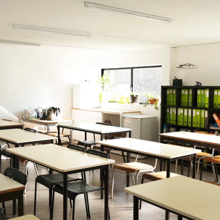 Uma sala de aula com mesas e cadeiras.
