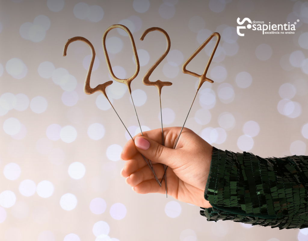 Uma mão segurando uma vela com o número 2020 escrito nela.