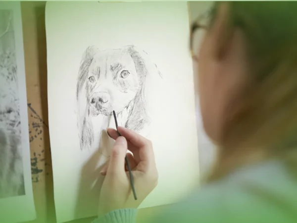 Pessoa desenhando um retrato detalhado de um cachorro com Explicações de Desenho A 12.º Ano. Pacote de Horas em bloco de desenho.