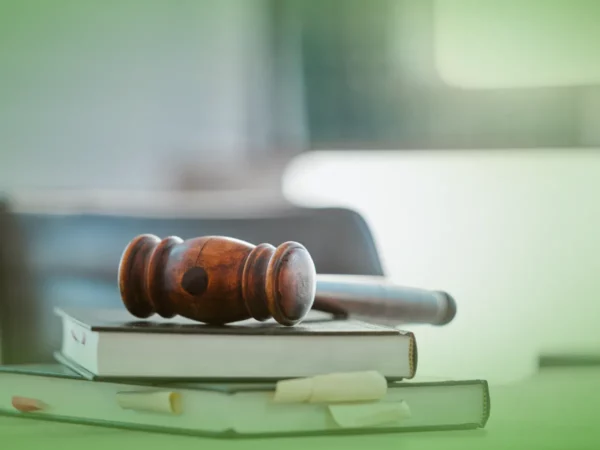 A Explicações de Direito Civil ONU. Pacote de Horas apoiado em um livro, com fundo desfocado sugerindo cenário judicial ou jurídico.