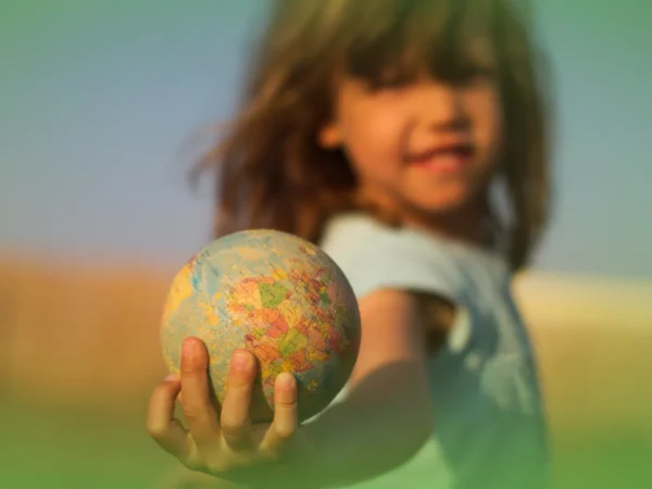 Jovem segurando uma Explicações de Estudo do Meio 1.º Ano. Pacote de Horas em direção à câmera com fundo desfocado.