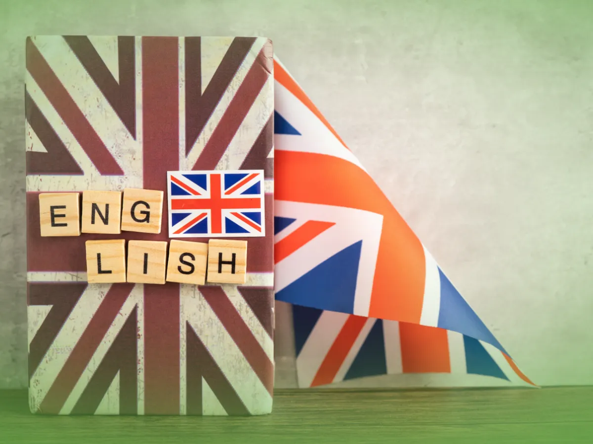 A Explicações de Inglês 10.º Um livro embrulhado num desenho Union Jack com peças Scrabble escritas "INGLÊS" na frente.