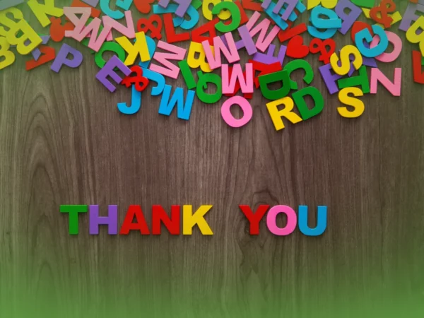 Explicações de Inglês 4.º Ano . Pacote de Horas espalhado sobre uma superfície de madeira com as palavras “obrigado” dispostas ao centro.