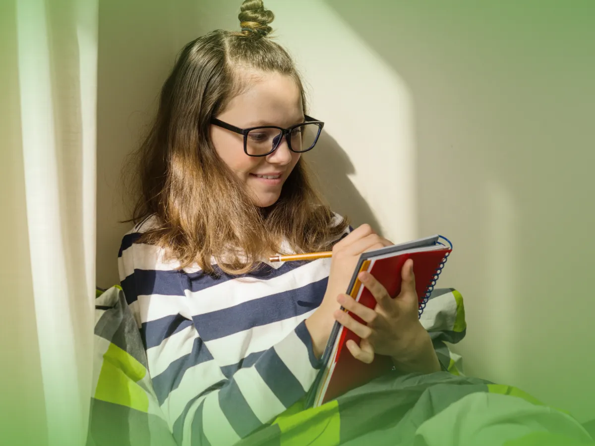 Uma jovem de óculos lendo Explicações de Língua Portuguesa 9.º Ano. Pacote de Horas em um tablet, sentado perto de uma janela com a luz do sol filtrada pelas cortinas verdes.