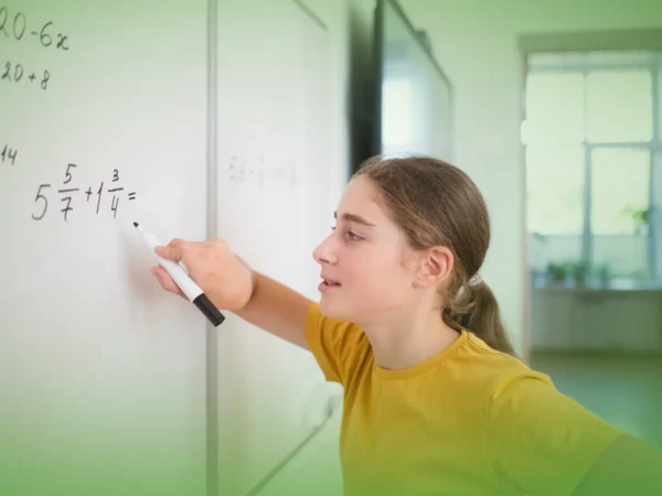 Uma jovem de camisa amarela escreve frações num quadro branco numa sala de aula iluminada, usando as Explicações de Matemática 6.º Ano. Pacote de Horas.