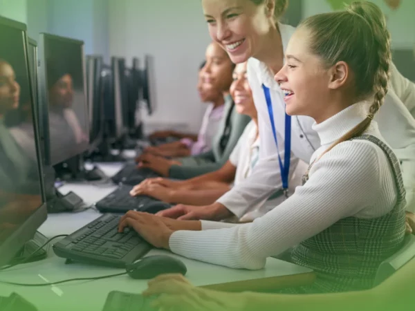 Um professor e alunos sorrindo enquanto usam Explicações de Tecnologias de Informação e Comunicação (TIC) 8.º Ano . Pacote de Horas em sala de aula.