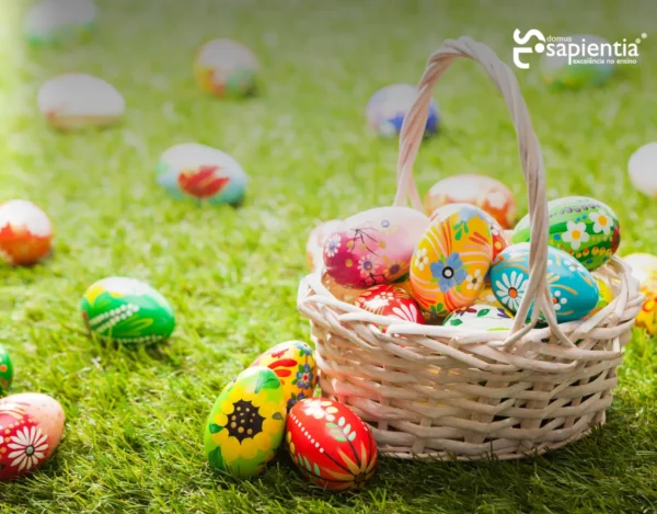 Uma cesta de vime cheia de ovos de Páscoa coloridos em um gramado.