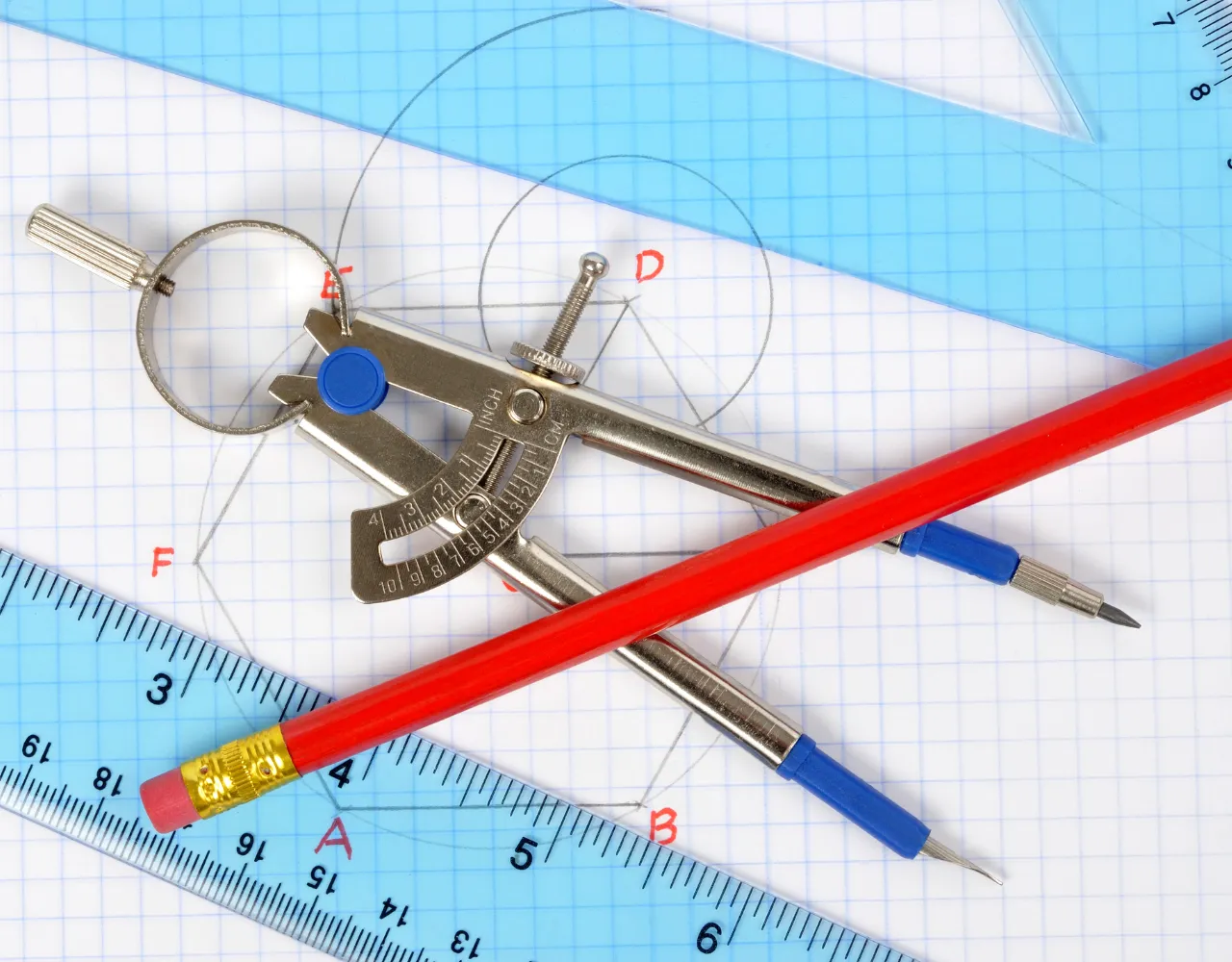 Uma bússola de metal, lápis vermelho, lapiseira azul e réguas de plástico azuis com medidas em papel milimetrado com desenhos geométricos e pontos rotulados.